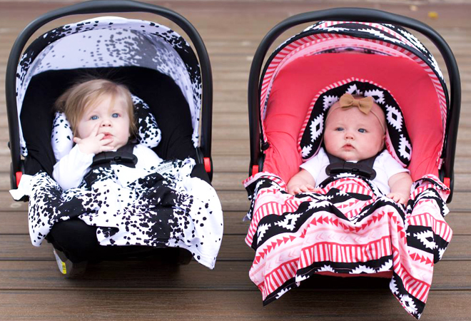Two Babies in Baby Carseats with Colorful Canopy Covers