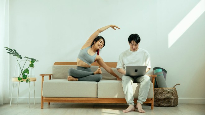 A Couple Sitting on a Couch Looking at their Laptop