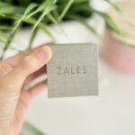 A Hand Holding a Box of Zales Personalized Cursive Name Necklace