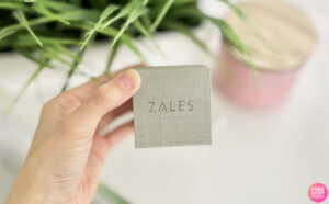 A Hand Holding a Box of Zales Personalized Cursive Name Necklace