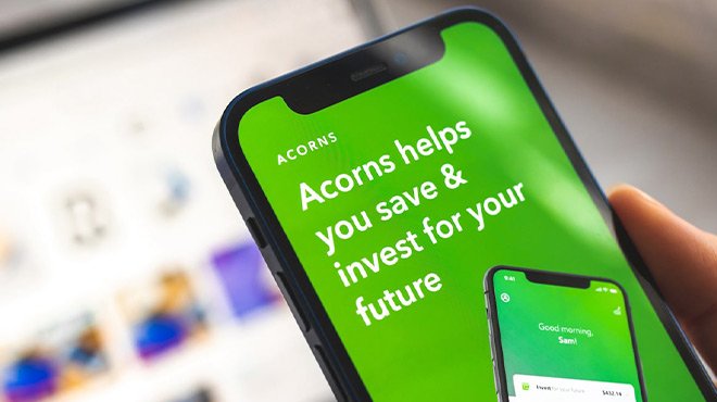 A Person Holding a Phone with Acorns on the Background