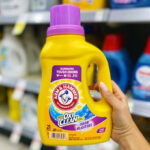 Hand Holding Arm & Hammer Plus Oxi Clean Detergent