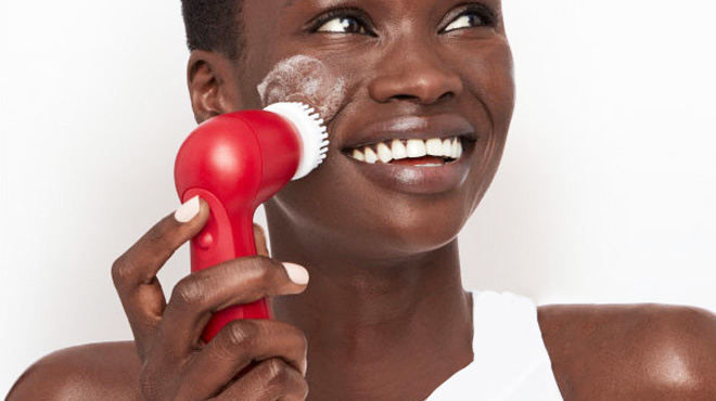 woman using olay cleansing device