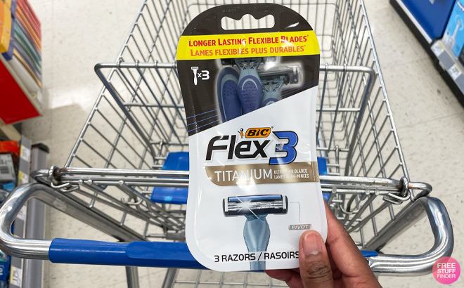 A Hand Holding BIC Flex 3 Razors in front of Walgreens Cart