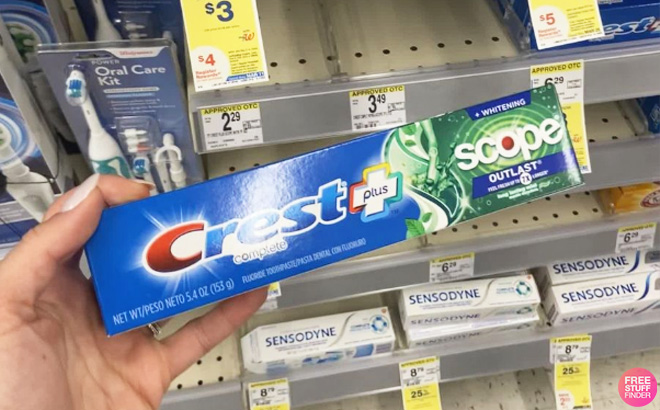 Hand Holding a Crest Toothpaste at Walgreens