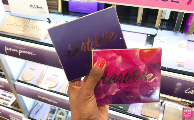 Hand Holding two Tarte Tartelette Eyeshadow Palettes