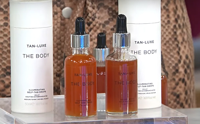 Tan Luxe The Body Self Tan Drops Two Bottles and Boxes on a Glass Shelf