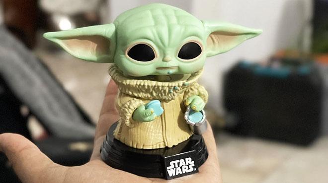 hand holding funko pop baby yoda figurin