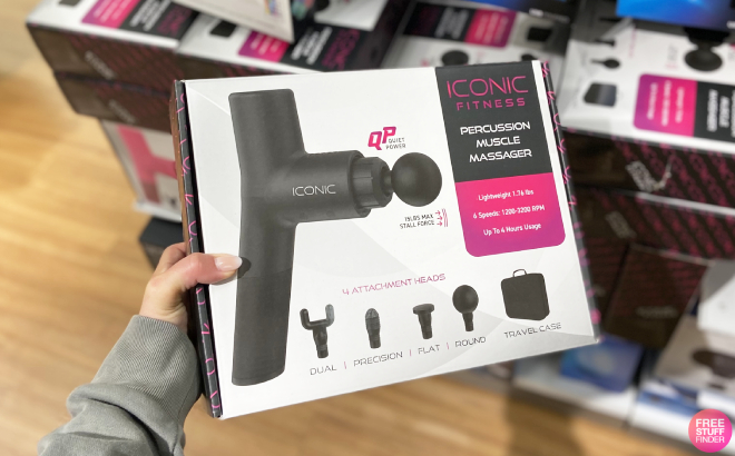 A Hand Holding Iconic Percussion Muscle Massage Gun Box