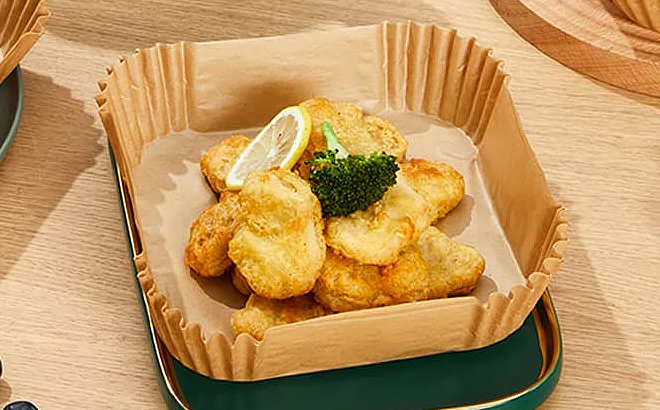 Air Fryer Parchment Paper Liner with Chicken Nuggets and Toppings on a Table