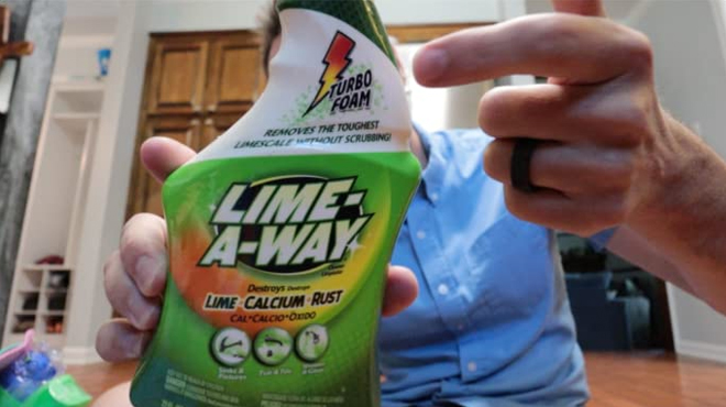 Man holding a bottle of Lime A Way Bathroom Cleaner Spray