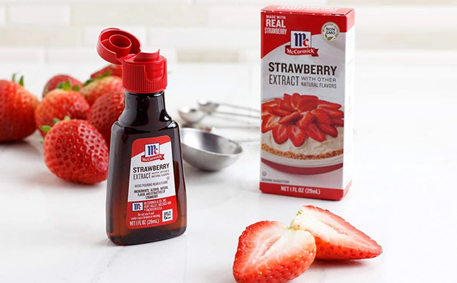 McCormick Strawberry Extract on a Kitchen Counter with Strawberries and Measuring Spoon