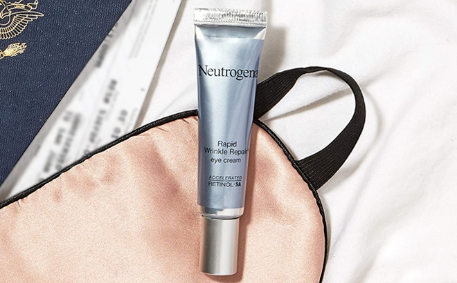 Neutrogena Rapid Wrinkle Repair Eye Cream on a Table with Eye Mask and Passport
