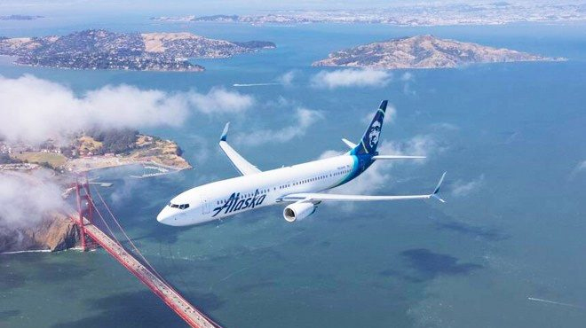 Plane in the Air with Alaska Airlines Logo over a City