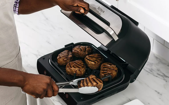 Woman Cooking Meat on the Ninja Foodi 6 in 1 Smart XL Indoor Grill and Air Fryer