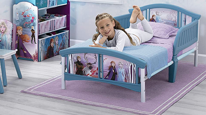 Girl Lying on Delta Children Disney Frozen Toddler Bed with Mattress