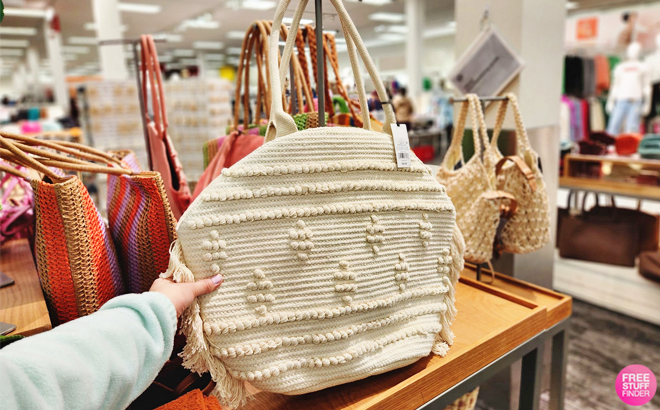 Hand Holding a Shade Shore Straw Fringe Tote Handbag in Off White