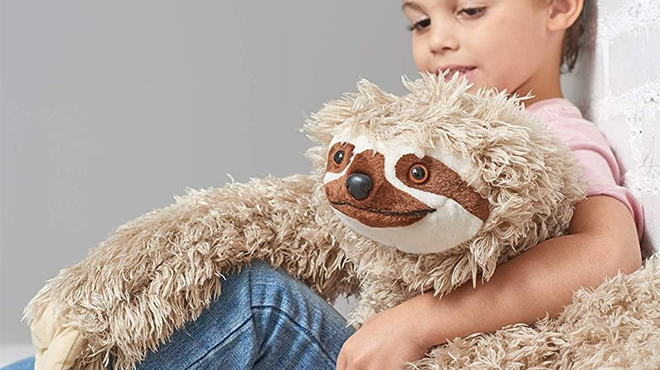 A boy resting his arms on the Wild Republic 30 Inch Jumbo Cloth Plush