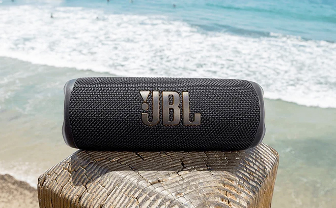 JBL Flip 6 Portable Waterproof Bluetooth Speaker on a Wooden Post