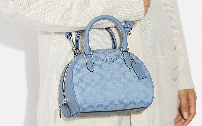 Woman Wearing Coach Outlet Sydney Satchel In Signature Chambray in Cornflower