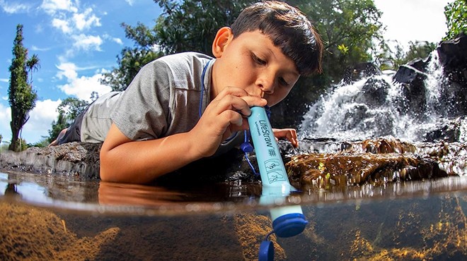 A Boy Drinking Water Using LifeStraw Personal Water Filter