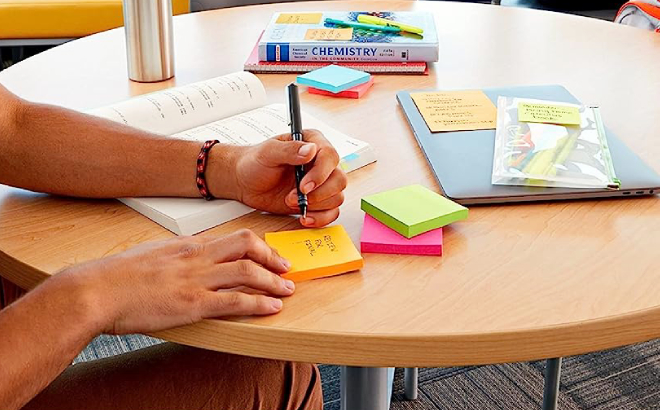 A Guy Writing on His Post it Super Sticky Notes