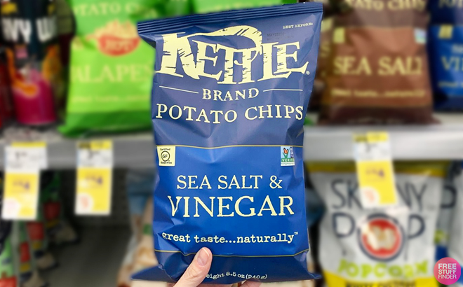 https://www.freestufffinder.com/wp-content/uploads/2023/07/A-Hand-Holding-Kettle-Brand-Potato-Chips-in-Sea-Salt-and-Vinegar-Flavor.jpg