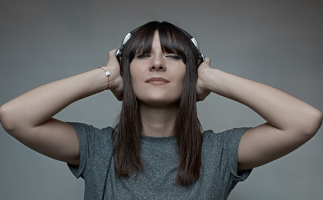 A Woman Wearing a Headset and Listening Music