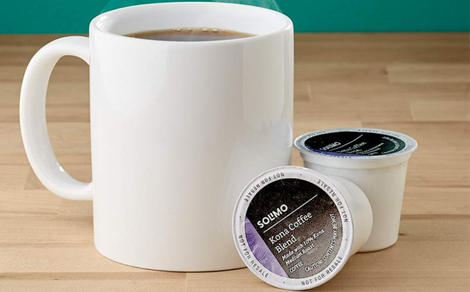 Amazon Brand Solimo 100 Count Medium Roast K Cup Pods Next to a Cup of Coffee