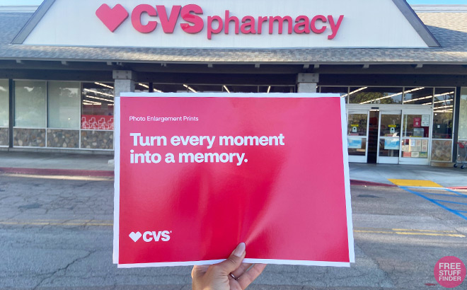 A Person Holding CVS Photo Prints in an Envelope in front of a CVS Store