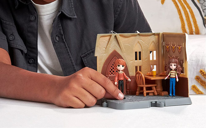 a Kid Playing with a Harry Potter Minis Three Broomsticks Playset