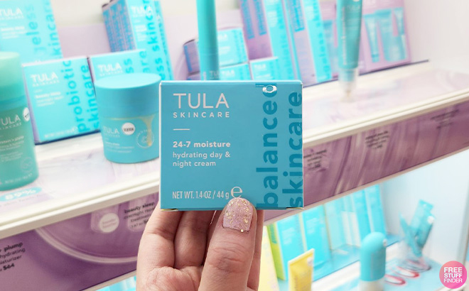 A Woman Holding Tula 24-7 Moisture Hydrating Day & Night Cream