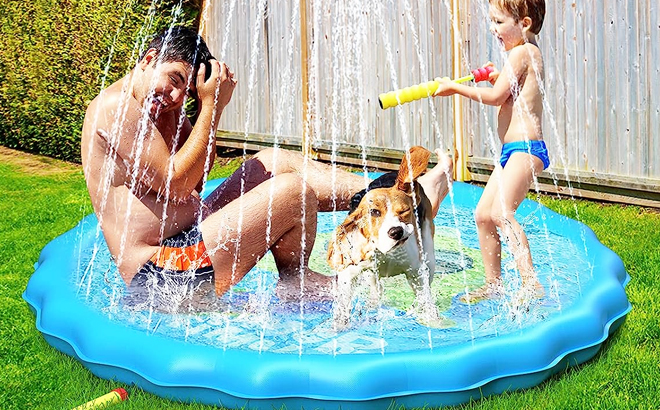 Father and son together with their pet playing on the Qpau Non Slip Splash Pad