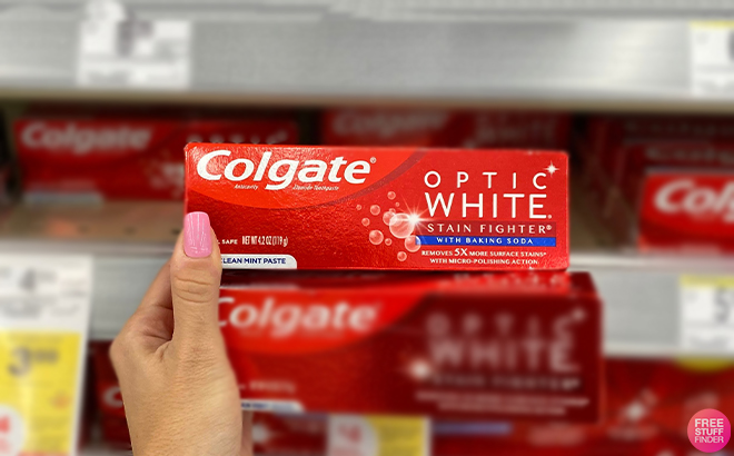 Hand Holding Colgate Optic White Stain Remover Toothpaste at Walgreens