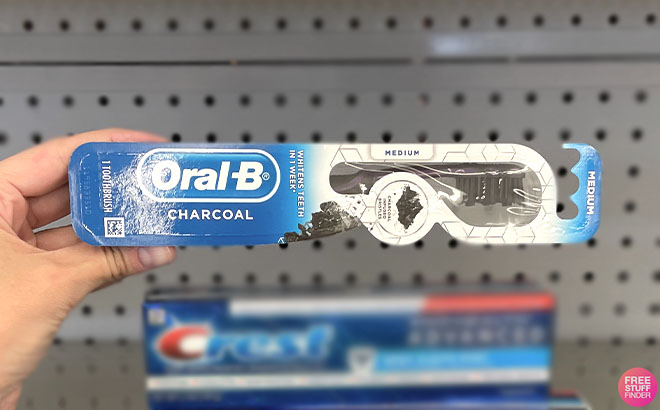 Hand Holding Oral B Toothbrush