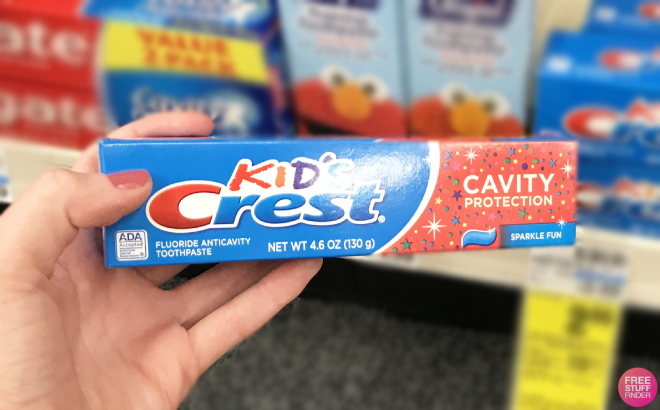 Hand Holding a Crest Kids Sparkle Fun Toothpaste