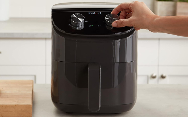 Hand Operating the Buttons on the Instant Pot Essentials 4 Quart Air Fryer Oven