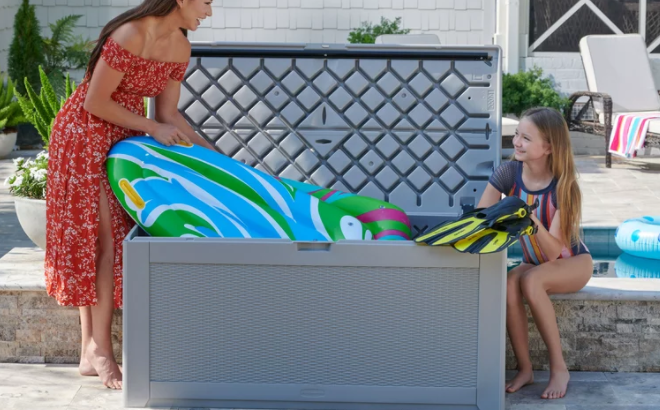 Lady Putting some Swim Gear inside the Rubbermaid 134 Gallon Extra Large Deck Box