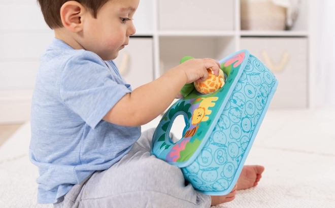 Little Boy Putting a Rollable Inside the Melissa Doug Rollables Take Along Tote