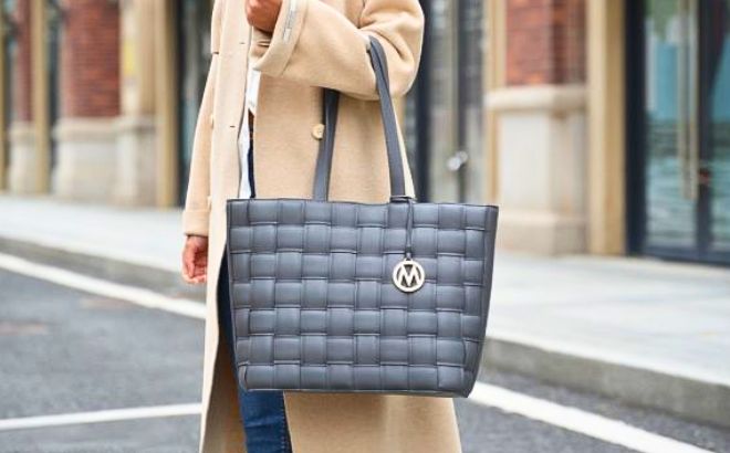 Woman on the street is wearing a Rowan Woven Vegan Leather Womens Tote Handbag in Charocal Gray color