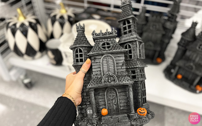 a Hand Holding Halloween Castle Figurine