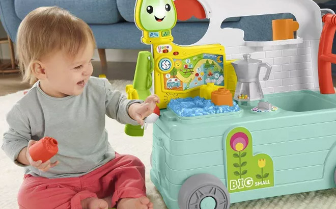 an Image of a Baby Playing with a Fisher Price Laugh Learn 3 In 1 On The Go Camper