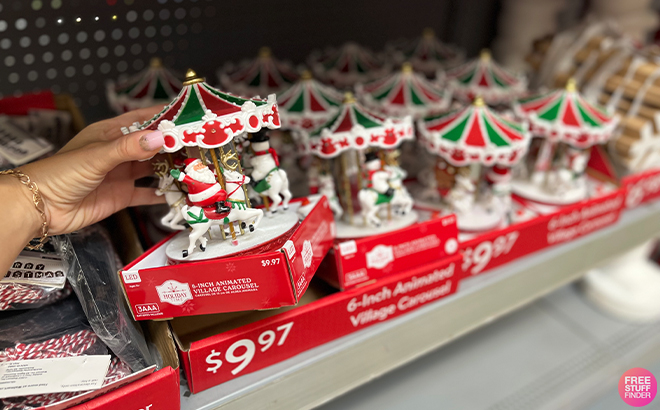 A Hand Holding a Santa Animated Village Carousel