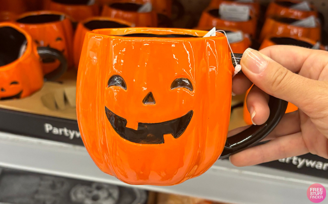 A Hand holding a Way To Celebrate Halloween Orange Pumpkin Ceramic Mug