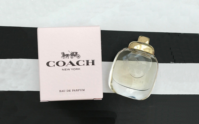 Coach New York Womens Perfume Displayed Next to Its Packagining on a Black and White Background 1