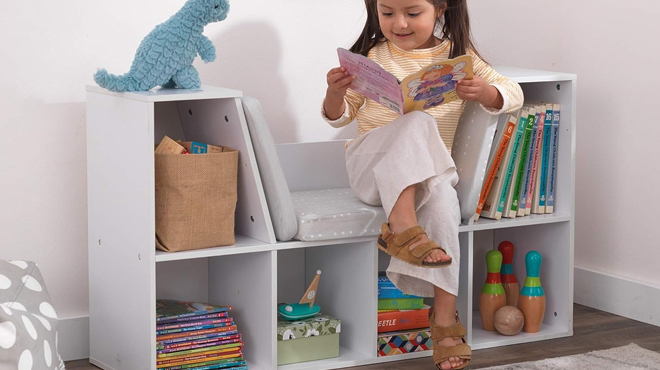 Girl Reading a book on a KidKraft Bookcase with Reading Nook inWhite Color