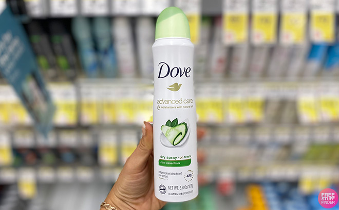 Hand Holding Dove Advanced Care Dry Spray in a Store Aisle