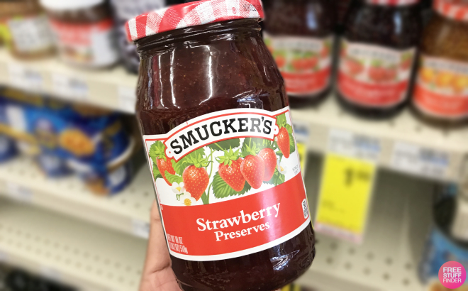 Hand Holding a Bottle of Smuckers Strawberry Preserves