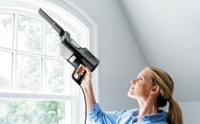 Lady Cleaning her Window Using the Shark Ultralight Corded Hand Vacuum