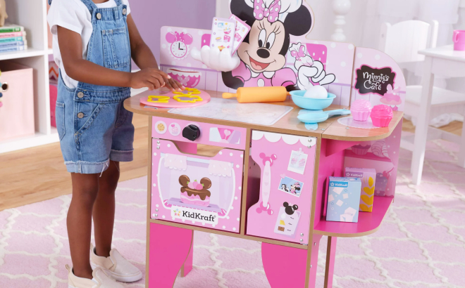 Little Girl Playing with KidKraft Minnie Mouse Wooden Bakery Cafe Playset